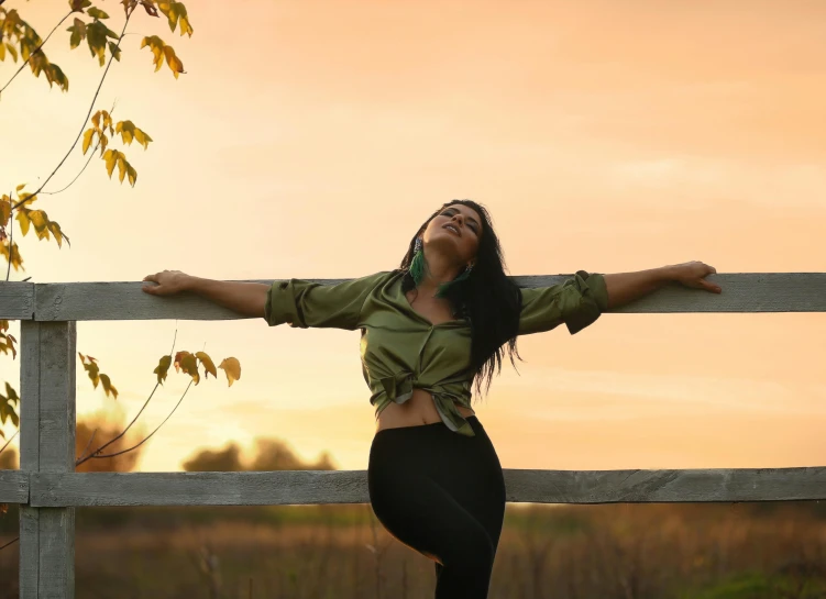 a woman standing on top of a wooden fence, pexels contest winner, she is in pure bliss, golden hour 8k, t pose, attractive pose