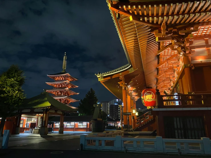 a building lit up at night with a pagoda in the background, inspired by Kanō Hōgai, pexels contest winner, wooden buildings, けもの, ad image