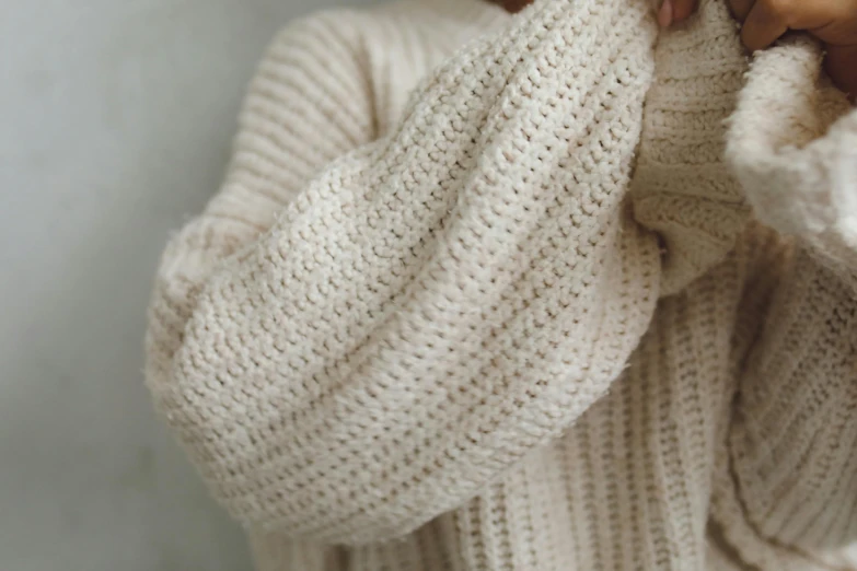 a close up of a person wearing a sweater, trending on pexels, hurufiyya, ivory, sustainable materials, bread, large tall