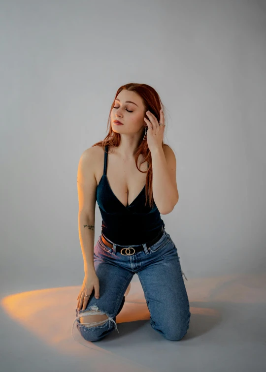 a woman sitting on the ground talking on a cell phone, an album cover, inspired by Jean Hey, trending on pexels, renaissance, better known as amouranth, ( ( ( wearing jeans ) ) ), studio photo portrait, sun behind her