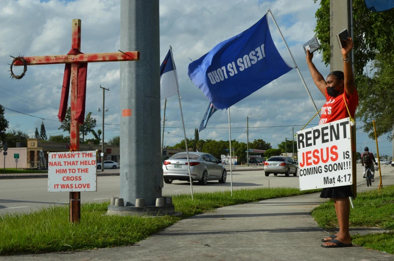 a man holding a sign in front of a cross, a photo, reddit, florida man, ap news photograph, crosswalks, beyond reproach