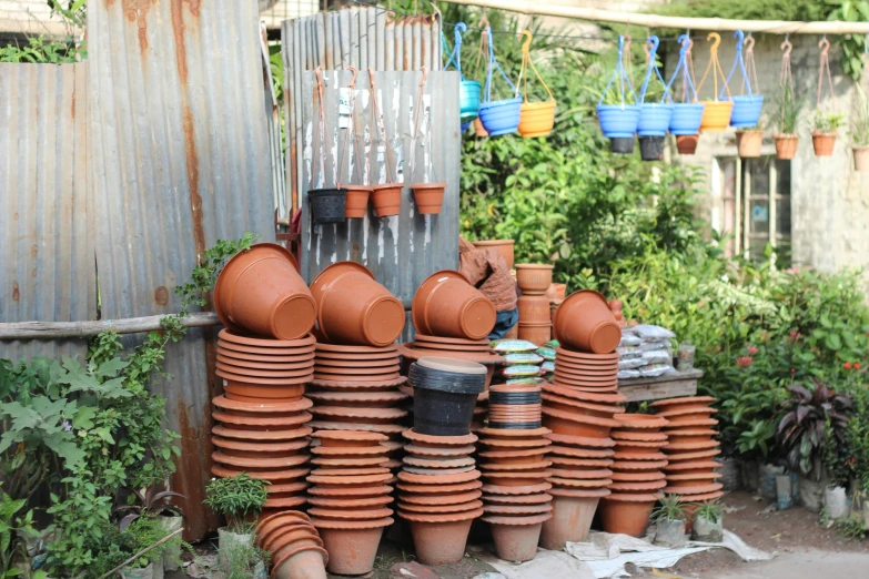 a bunch of clay pots stacked on top of each other, by Gwen Barnard, unsplash, plasticien, garden setting, tehran, quirky shops, 🦩🪐🐞👩🏻🦳