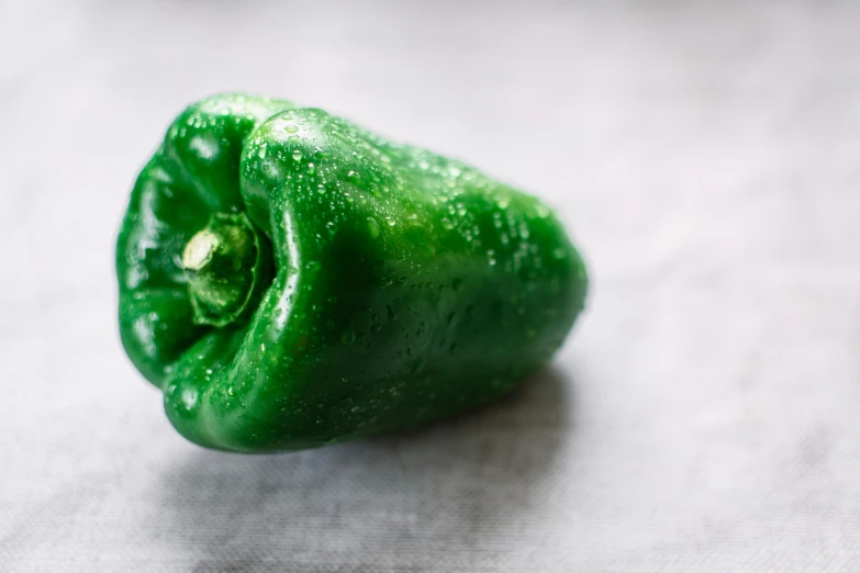 a green pepper sitting on top of a table, grey, 1 petapixel image, full product shot, fully covered