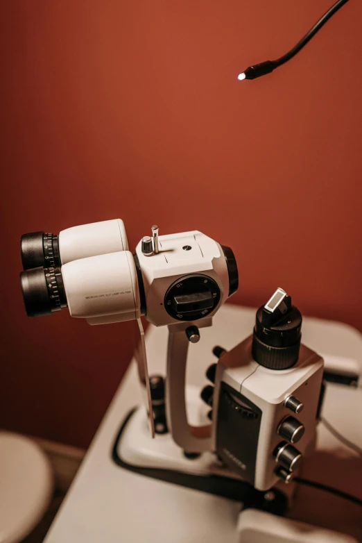 a microscope sitting on top of a table next to a toilet, black spot over left eye, up close shot, product shot, brown