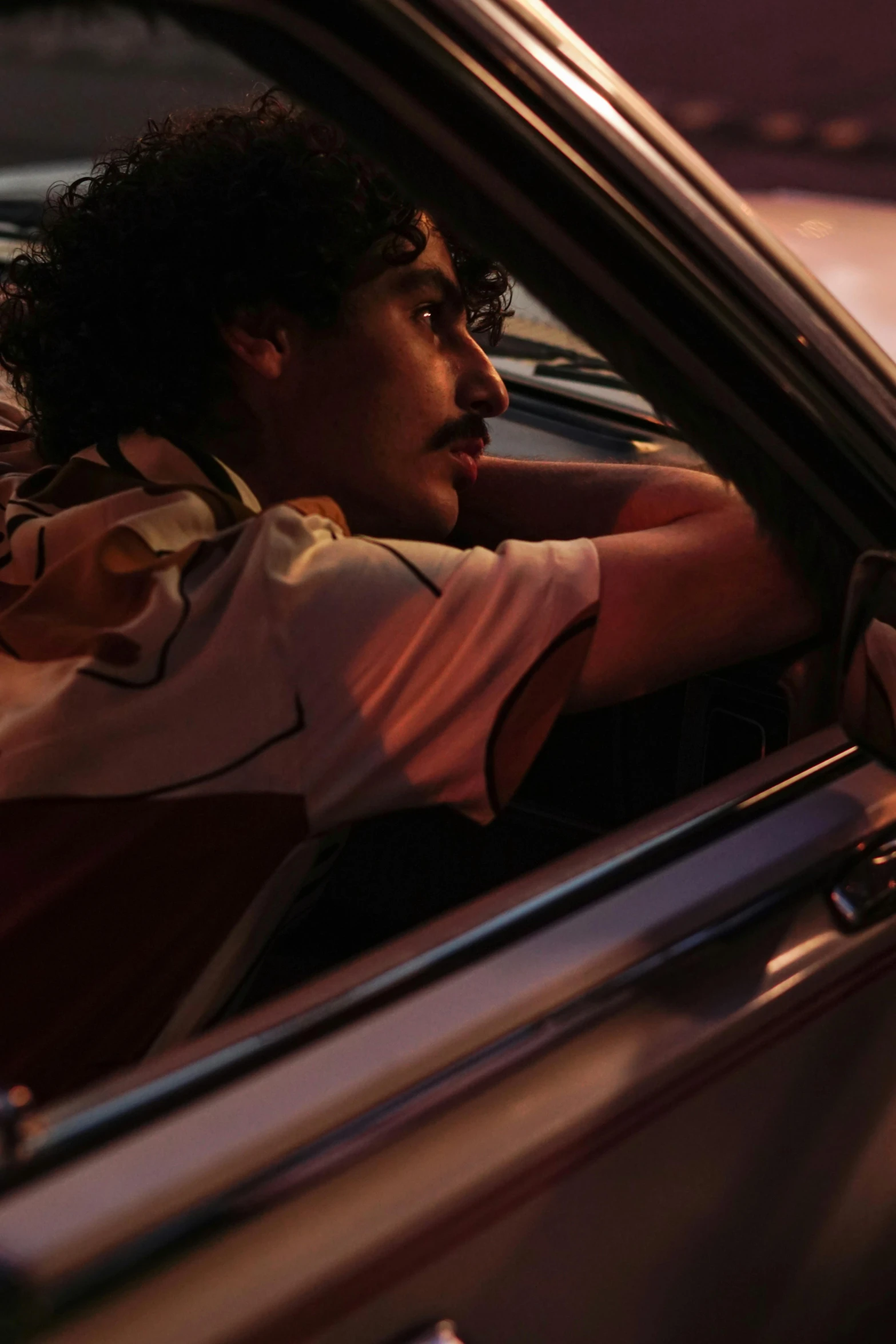 a woman sitting in the passenger seat of a car, an album cover, by Alexis Grimou, imaan hammam, raden saleh, handsome man, dynamic movie still