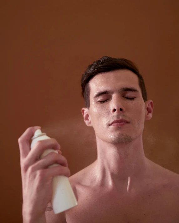 a shirtless man holding a spray bottle in front of his face, a stipple, trending on unsplash, non binary model, incense, wearing white leotard, warm skin tone