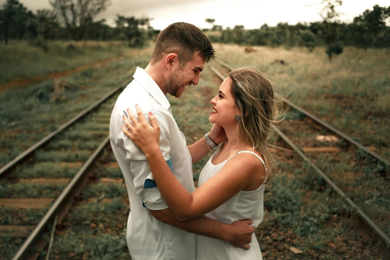 a man and a woman standing next to each other on train tracks, pexels contest winner, happening, ( ( ( ( kauai ) ) ) ), beautiful girlfriend, straya, white