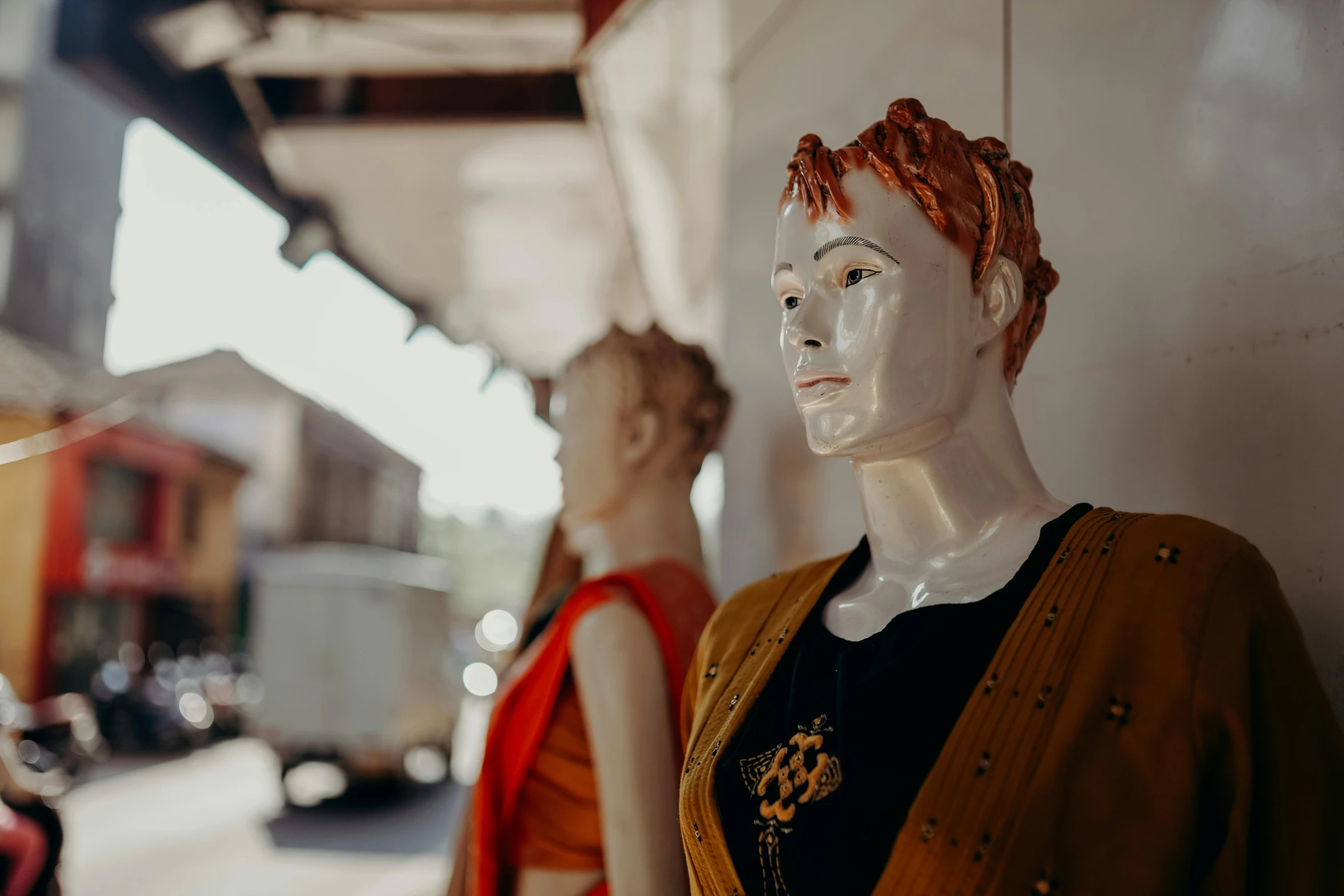 a couple of mannequins standing next to each other, a statue, trending on pexels, orange braided hair, bust view, vintage clothing, tribal clothing