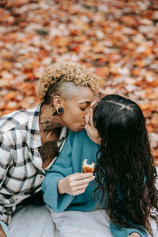 a man giving a woman a kiss on the cheek, by Carey Morris, trending on pexels, orange and brown leaves for hair, lesbians, eating cakes, mixed race