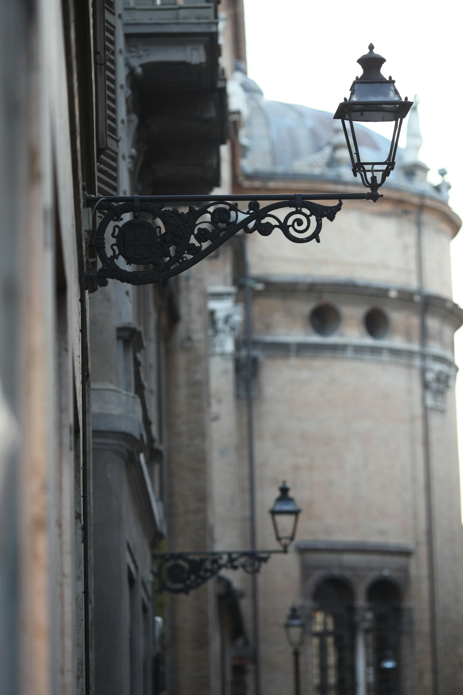 a street light hanging from the side of a building, a photo, by Coppo di Marcovaldo, renaissance, buttresses, seville, close - up photograph, view from the street