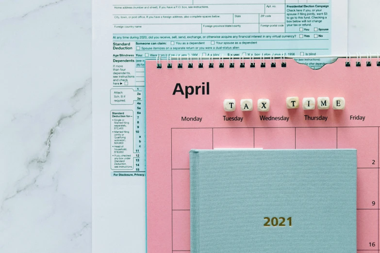 a calendar sitting on top of a desk next to a calculator, by Carey Morris, trending on pexels, hyperrealism, pink and teal, spring theme, thumbnail, 1 1 1 1