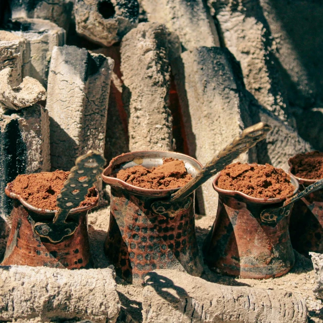 a group of clay pots sitting on top of a pile of rocks, ancient coffee machine, lerapi, rich in texture ), featured