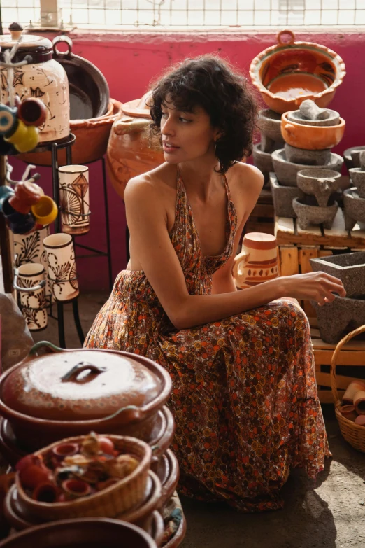 a woman sitting in a room full of pottery, wearing a flowing sundress, beautiful tan mexican woman, curated collections, market setting