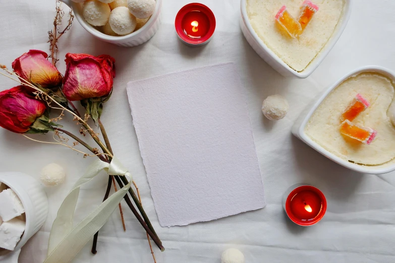 a white table topped with bowls of food and candles, inspired by Marie Laurencin, trending on pexels, process art, textured paper, pink, blank paper, white and purple