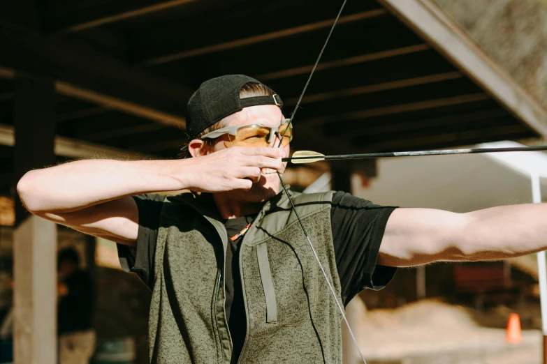 a man holding a bow and aiming at a target, pexels contest winner, wearing oakley sunglasses, lachlan bailey, mr beast, arrow