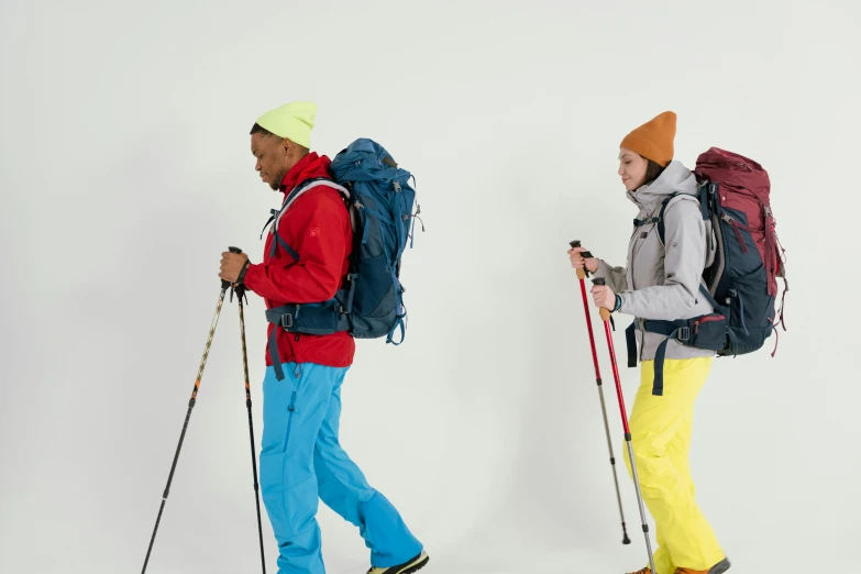 a couple of people standing next to each other on skis, trending on pexels, figuration libre, hiking clothes, on a gray background, full dynamic colour, pack