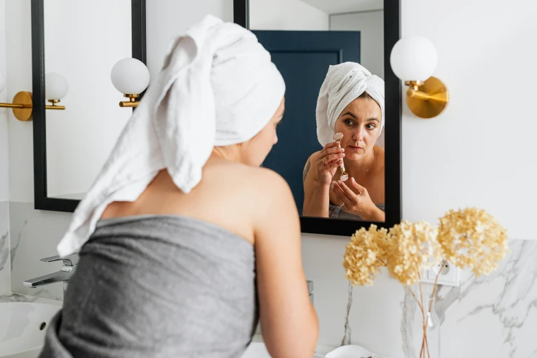 a woman that is standing in front of a mirror, trending on pexels, wearing a towel, manuka, bite her lip, girl with pearl earring