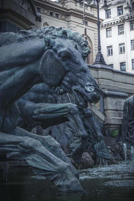 a statue of two horses in front of a building, by Adam Szentpétery, pexels contest winner, art nouveau, closeup of magic water gate, herds fighting, giant grave structures, buffalo