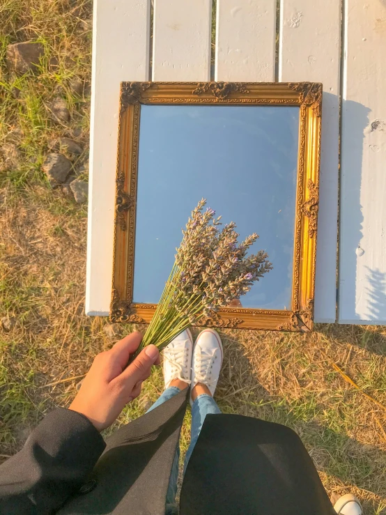 a person holding a bunch of flowers in front of a mirror, a picture, inspired by Vivian Maier, trending on unsplash, visual art, in a lavender field in france, sneaker photo, gold framed, ✨🕌🌙