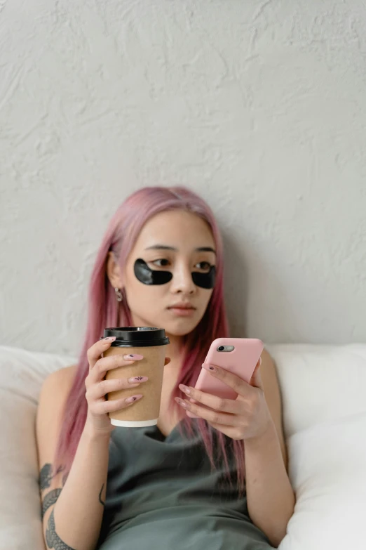 a woman with pink hair sitting on a bed looking at her cell phone, trending on pexels, aestheticism, coffee cups, black eye patch over left eye, bella poarch, android coffee shop