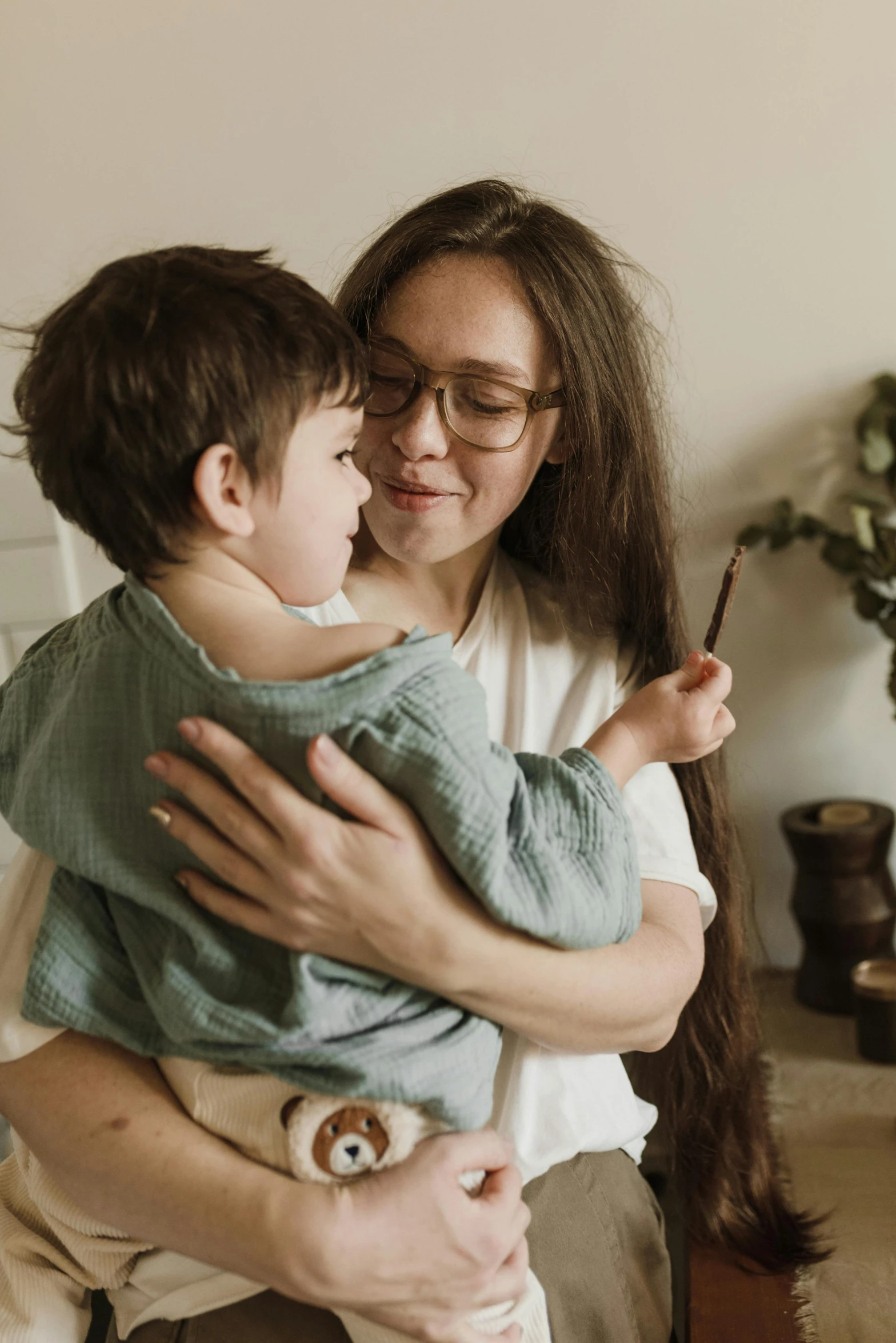 a woman holding a child in her arms, pexels contest winner, bowater charlie and brom gerald, at home, reassuring, cute boy