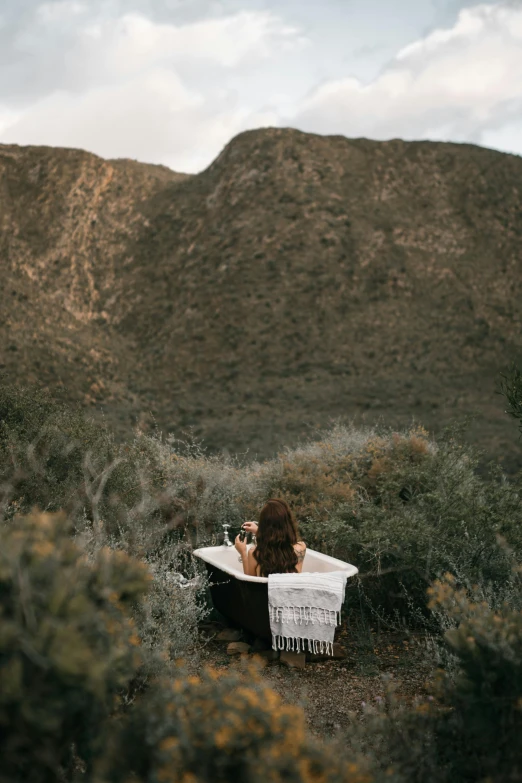 a woman taking a bath in a tub in the desert, by Jessie Algie, unsplash contest winner, australian tonalism, hollister ranch, outdoors mesa setting, drink, cape