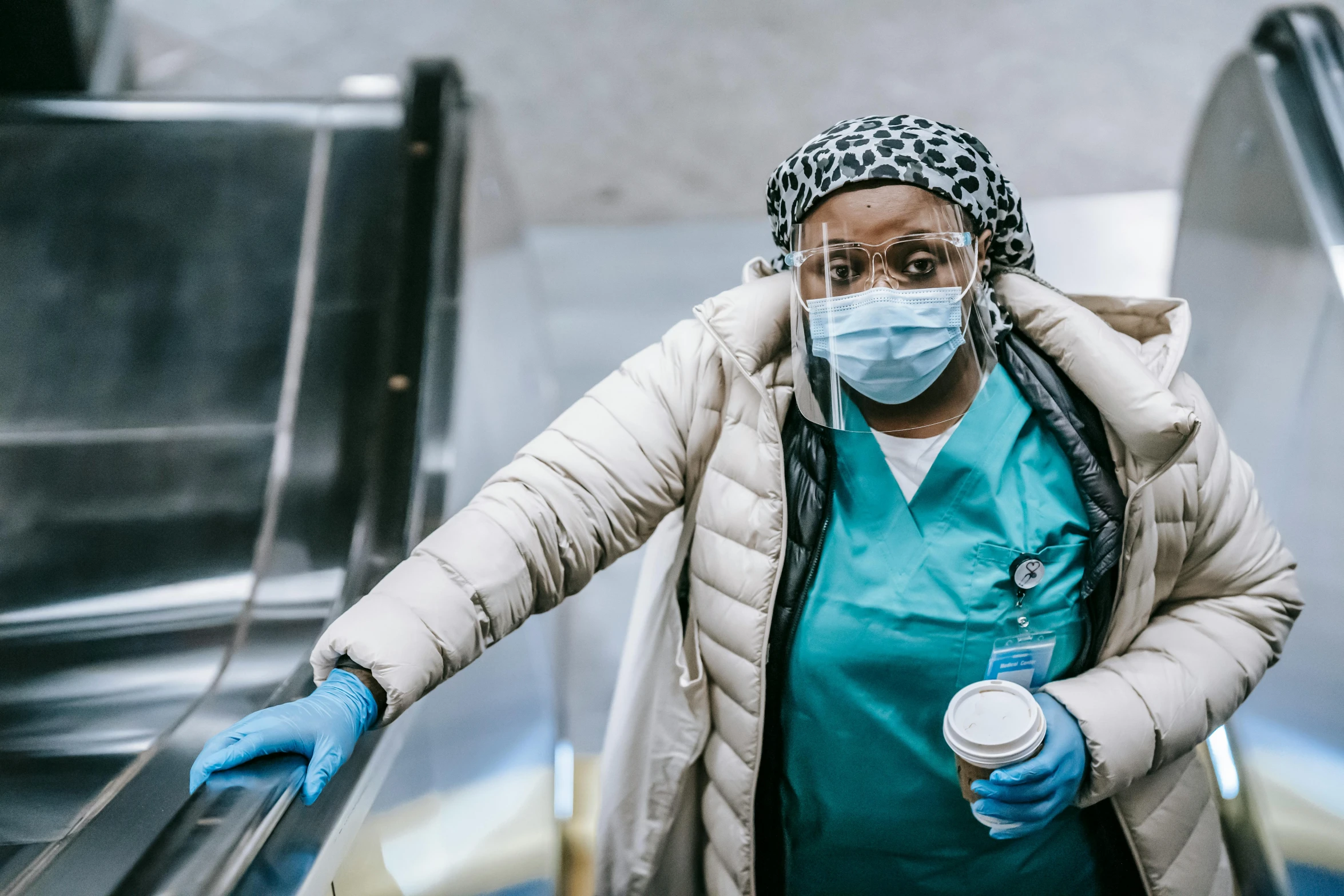 a woman wearing a mask and gloves on an escalator, a portrait, pexels contest winner, nurse scrubs, avatar image, photo of a black woman, surgical supplies