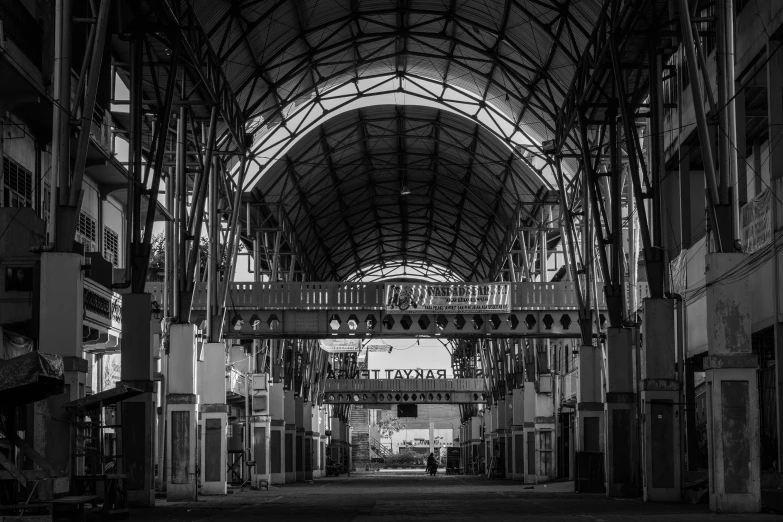 a black and white photo of a train station, by Patrick Pietropoli, unsplash contest winner, art nouveau, old jeddah city alley, steel archways, manila, market