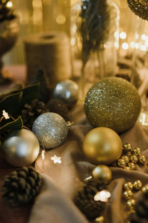 a close up of christmas decorations on a table, trending on pexels, baroque, golden orbs and fireflies, charcoal and champagne, in a medium full shot, landscape shot