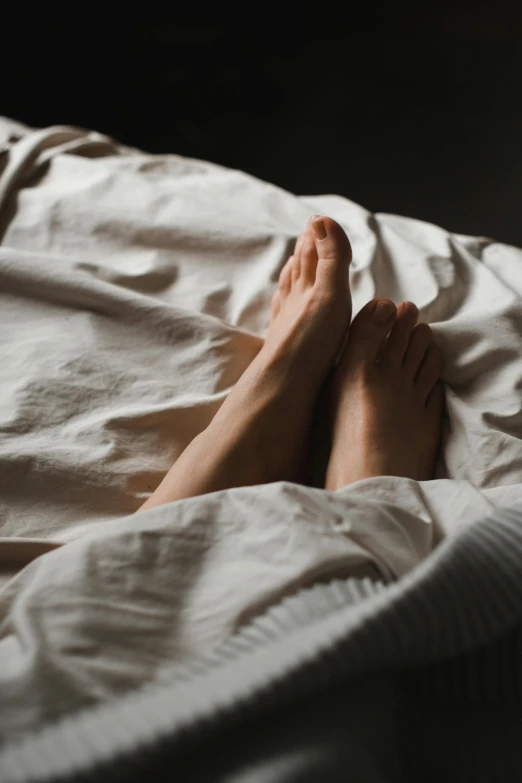 a close up of a person's feet on a bed, pexels contest winner, full-body, covered with blanket, soft shade, sprawled out