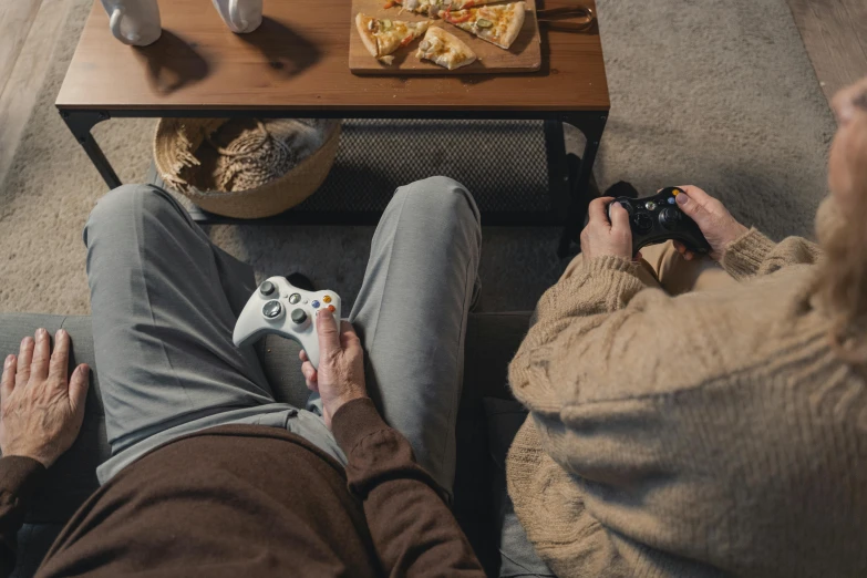 two people sitting on a couch playing a video game, by Adam Marczyński, trending on pexels, renaissance, hide the pain harold, xbox series x, lawther sit at table playing dnd, **cinematic