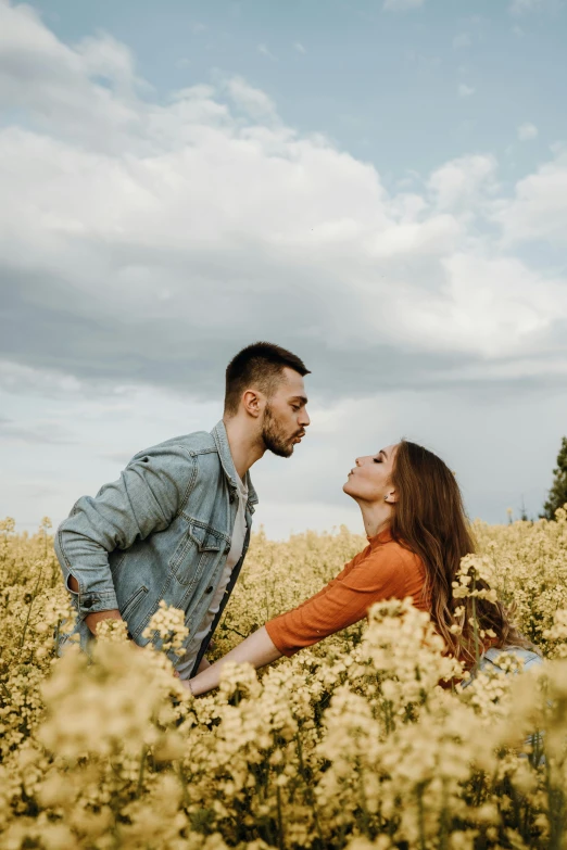 a man and woman in a field of yellow flowers, pexels contest winner, flirting, plain background, instagram post, on ground
