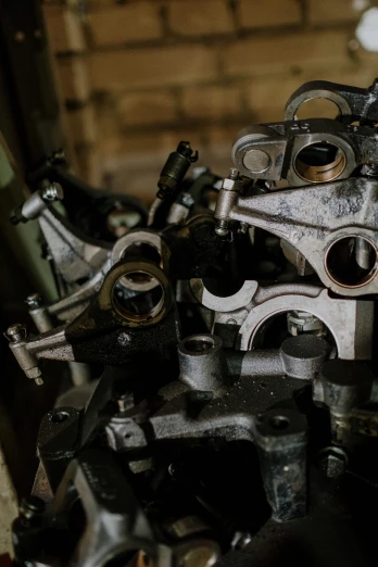 a close up of a motorcycle engine in a garage, an abstract sculpture, by Tobias Stimmer, pexels contest winner, assemblage, car parts concept, faded worn, multi-part, heavy machinery