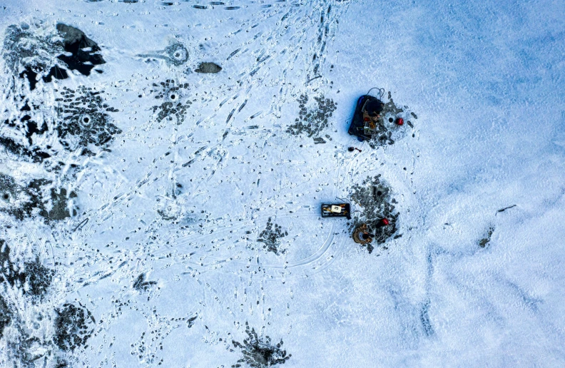 a group of people standing on top of a snow covered slope, by Else Alfelt, pexels contest winner, land art, game top down view, crates and parts on the ground, on the surface of an asteroid, björk