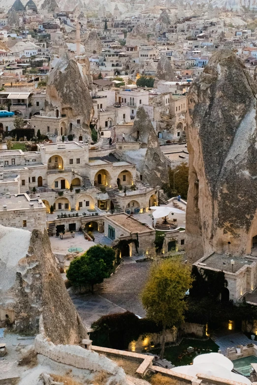 a view of a city from the top of a hill, by irakli nadar, buildings carved out of stone, full frame image