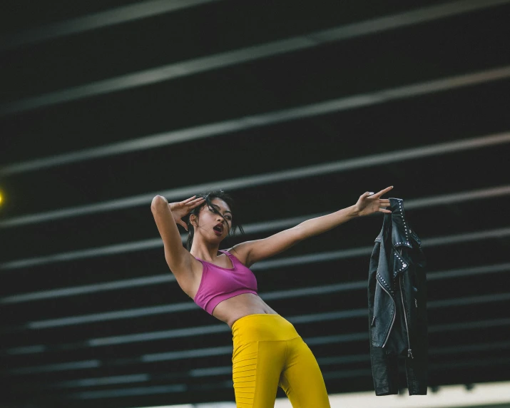 a woman in a pink top and yellow pants, pexels contest winner, brandon woelfel, leather clothing, workout, ad image