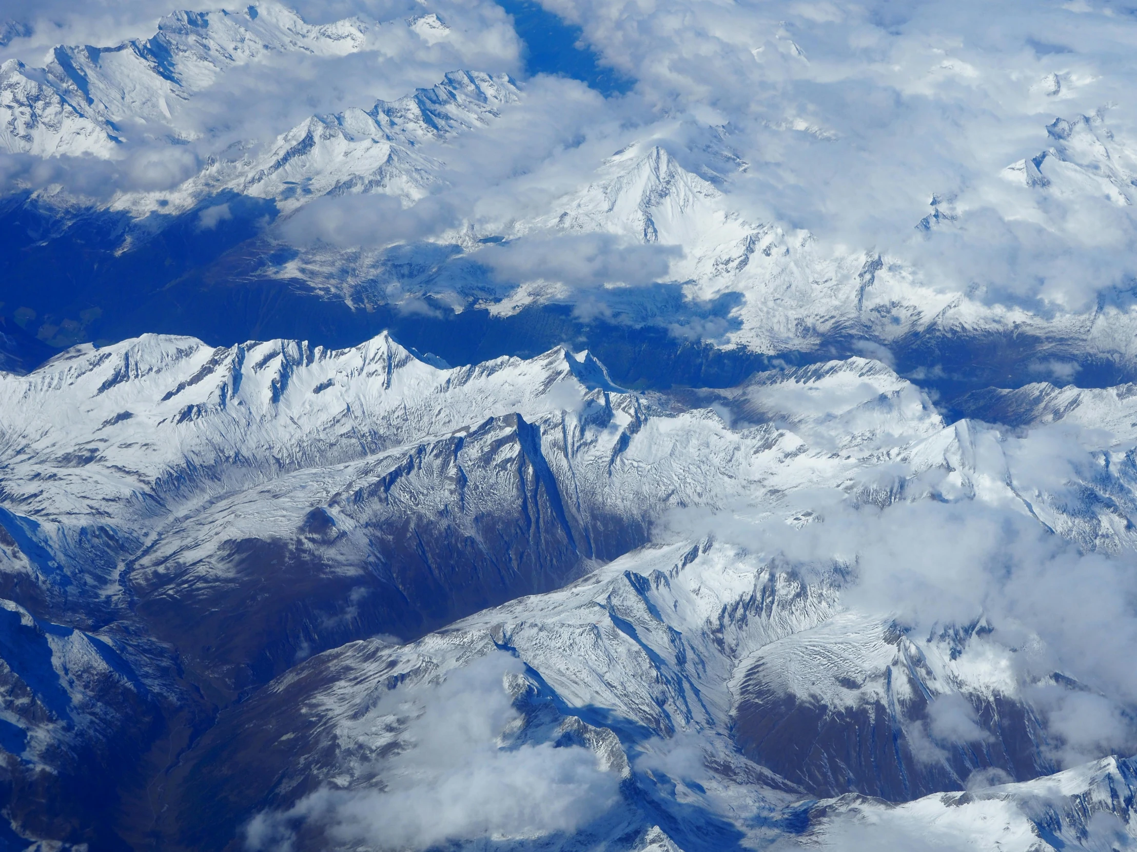 a view of snow covered mountains from an airplane, by Peter Churcher, pexels contest winner, hurufiyya, thumbnail, several continents, a cozy, 1 4 9 3