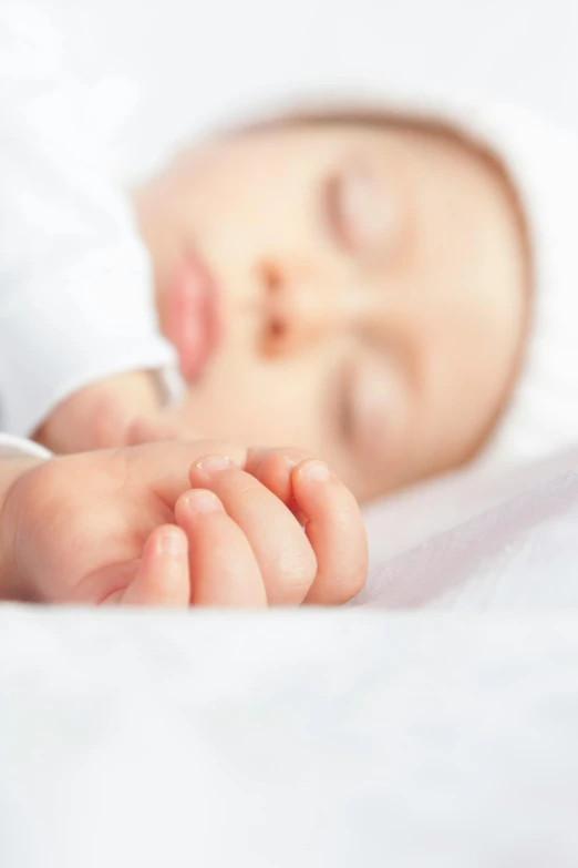 a close up of a baby sleeping on a bed, sleek hands, right hand side profile, digital image, press shot