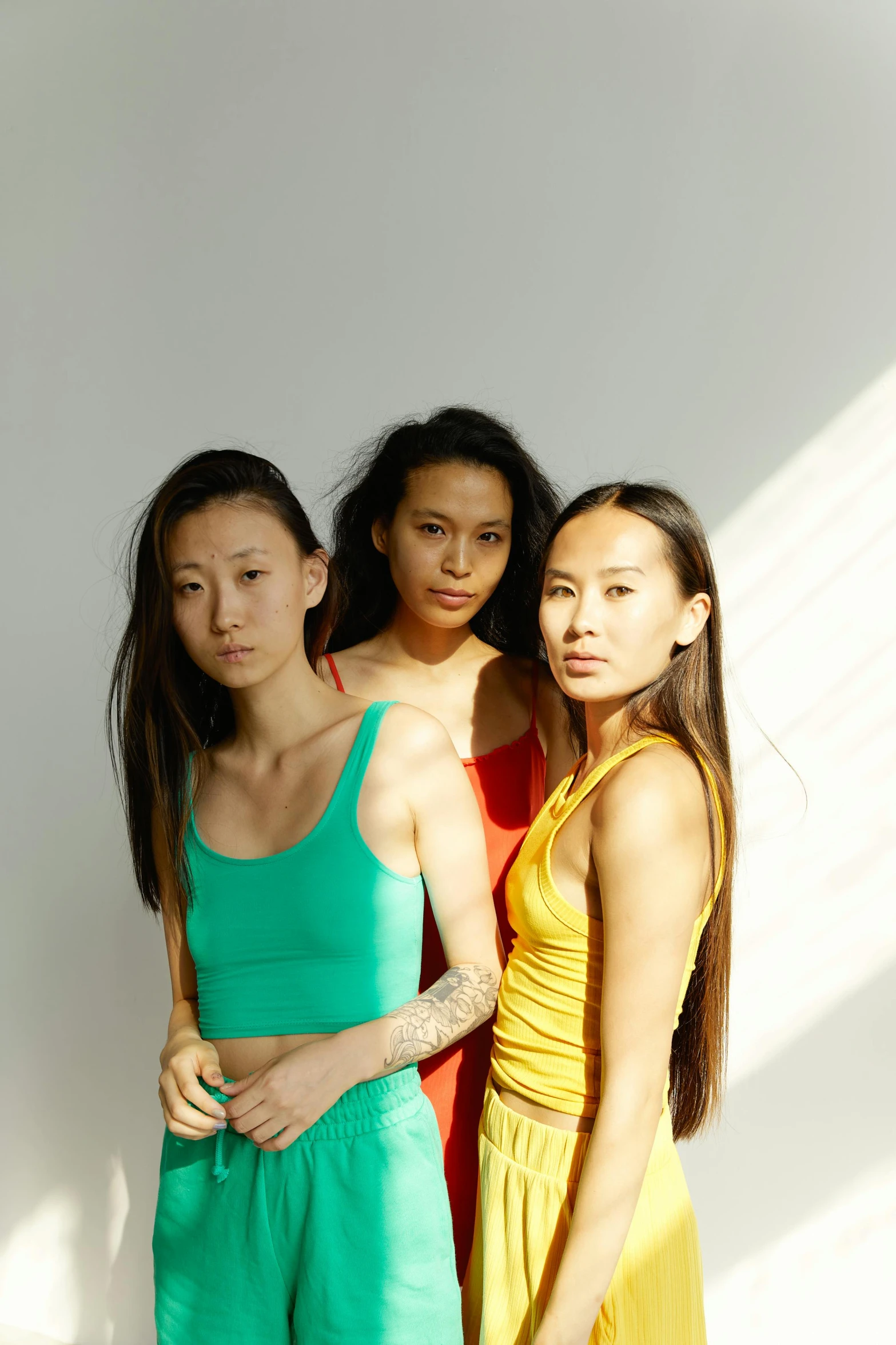 a group of three women standing next to each other, inspired by Ren Hang, unsplash, gutai group, crop top, jingna zhang, wearing tank top, long flat hair