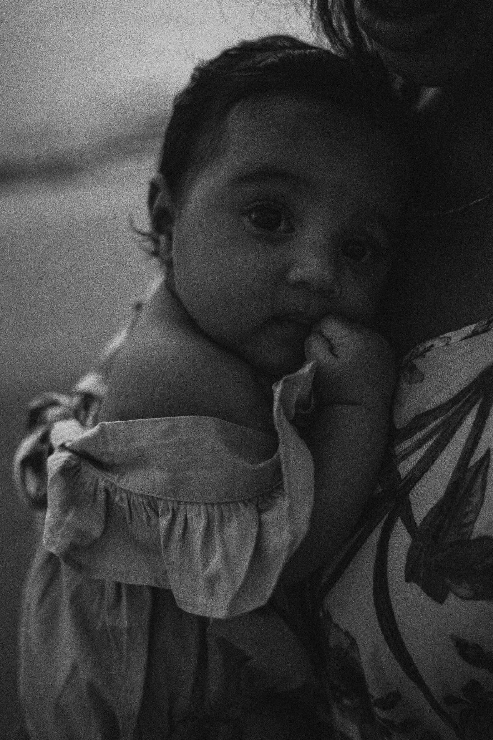 a black and white photo of a woman holding a baby, a black and white photo, unsplash, realism, indian girl with brown skin, ✨🕌🌙, summer night, cute face