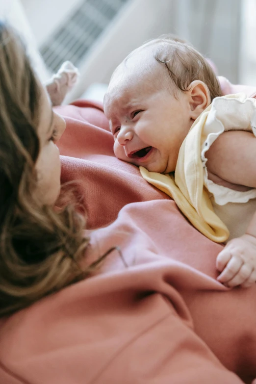 a woman holding a baby in her arms, pexels, incoherents, crying and puking, full frame image, screensaver, coloured