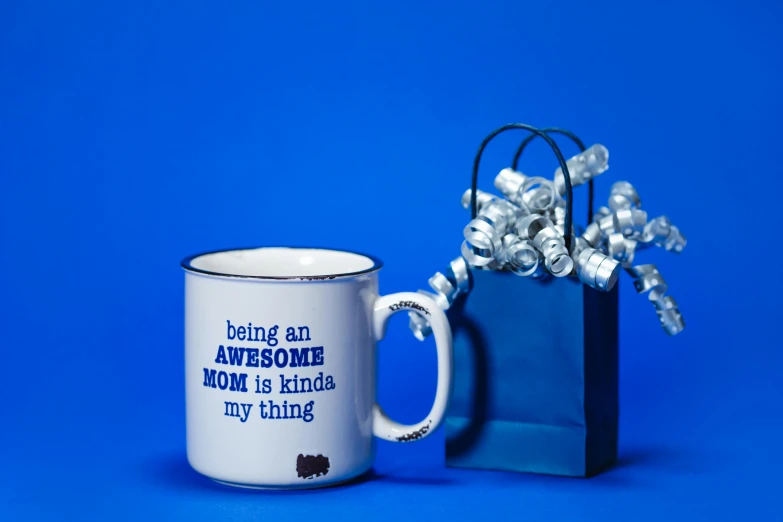 a mug that says being an awesome mom is kind of my thing, an album cover, pop art, silver and sapphire, 35 mm product photo”