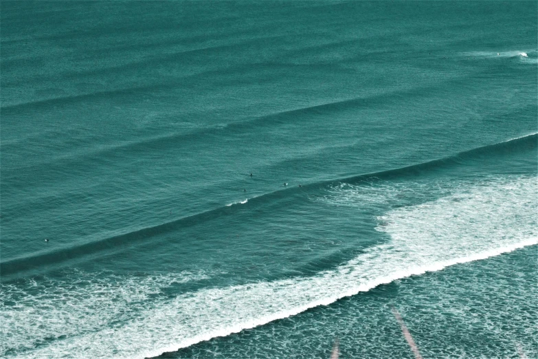a person riding a surfboard on top of a wave, a stipple, pexels contest winner, plasticien, dark teal, in a row, cornwall, birds eye photograph