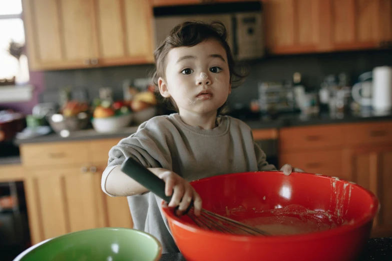a young boy mixing food in a red bowl, pexels, avatar image, kek, focused photo, maintenance