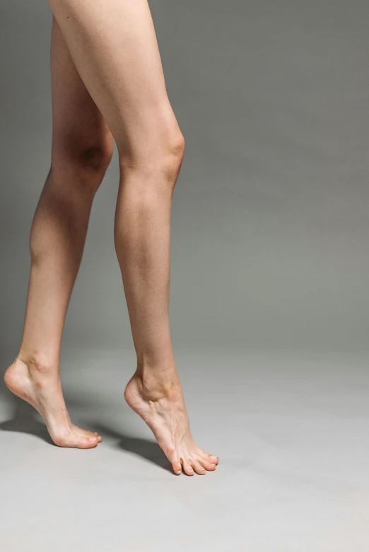 a woman in a bikini posing for a picture, shutterstock, arabesque, veins merged feet head, on a gray background, walking down, ap