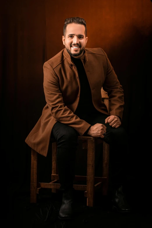 a man sitting on top of a wooden chair, a character portrait, inspired by Fathi Hassan, professional photo-n 3, dramatic smile pose intricate, brown clothes, candid flash photography