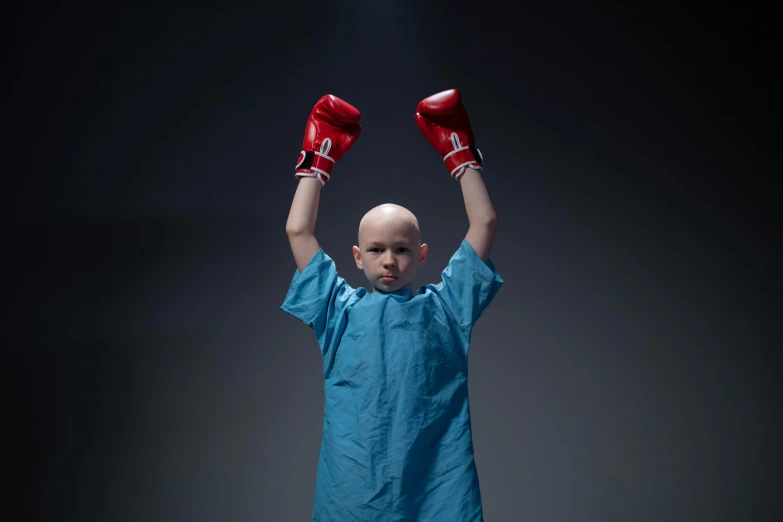 a young boy in a blue shirt and red boxing gloves, an album cover, by Alison Geissler, shutterstock contest winner, tumors, a bald, die antwoord, fighting a war