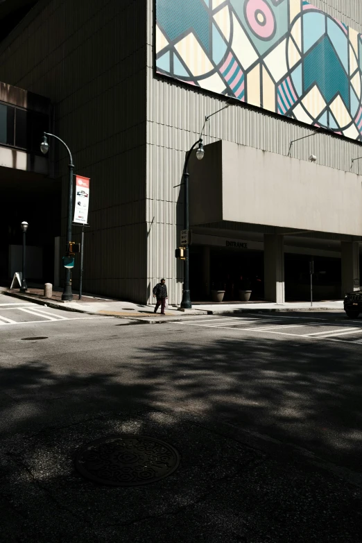 a man riding a skateboard down a street next to a tall building, inspired by Vivian Maier, unsplash, postminimalism, downtown jacksonville florida, ignant, cars parked underneath, deserted shinjuku junk