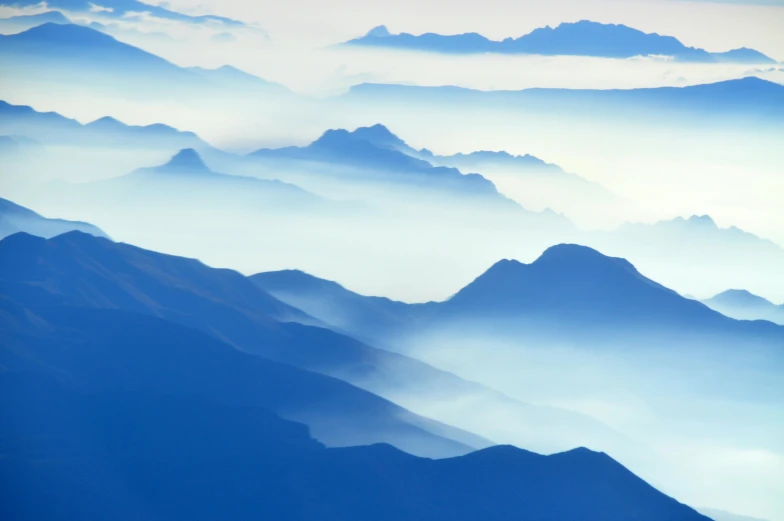 a view of the mountains from an airplane, pexels contest winner, precisionism, blue gradient, multiple stories, soft mist, lpoty