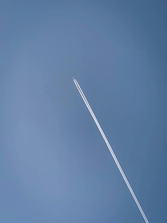 a large jetliner flying through a blue sky, by Peter Churcher, unsplash, postminimalism, single long stick, thumbnail, high angle shot, meteor